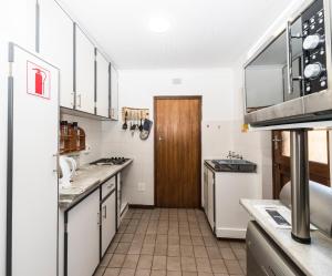 a kitchen with white cabinets and a wooden door at Estuary Cottage in Sedgefield