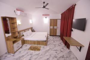 a bedroom with a bed and a flat screen tv at Sea View Varkala Beach Resort in Varkala