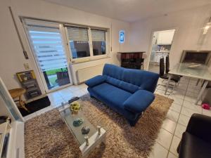 a living room with a blue couch and a table at Ferienwohnung Roersch in Freudenburg