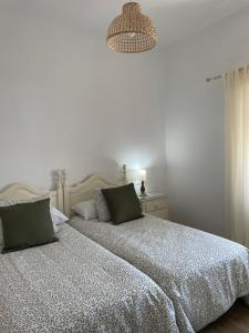 a bedroom with a bed and a chandelier at Los Granainos in Arcos de la Frontera