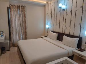 a bedroom with a large white bed in a room at Hotel Varanasi Heritage in Varanasi