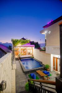 a swimming pool on the side of a house at Eric Dolphin Villa in Lovina