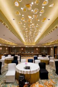 a banquet room with white tables and chairs and a ceiling with dishes at Gemini Continental, Hazratganj in Lucknow