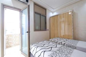 a bedroom with two beds and a sliding glass door at Riad Bollywood-Star Stay A in Benguerir