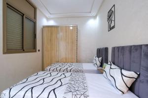 a bedroom with two beds and a window at Riad Bollywood-Star Stay A in Benguerir