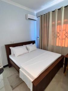 a bedroom with a bed in a room with a window at ANITHA EXECUTIVe LODGE in Kibaha +19 photos