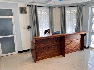 a woman sitting at a desk in a room at ANITHA EXECUTIVe LODGE in Kibaha