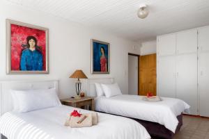 a bedroom with two beds and a painting on the wall at Estuary Cottage in Sedgefield +9 photos