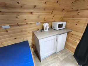 a small kitchen with a microwave on a counter at Barrhill Holiday Park - Glamping in South West Scotland - Stinchar in Girvan