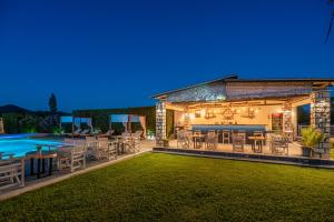 a backyard with chairs and a pool at night at A Ponte Studios & Apartments in Sykia Chalkidikis