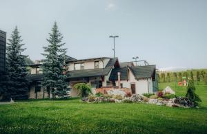 a house with a green lawn in front of it at Casa Cheile Dâmbovicioarei - Cabana 3 in Podu Dîmboviţei