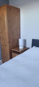 a bedroom with a bed and a wooden cabinet at This is the Place in Ballinrobe