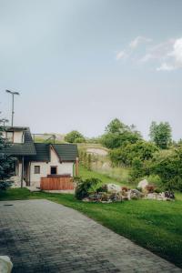 a house with a brick driveway in front of a yard at Casa Cheile Dâmbovicioarei - Cabana 3 in Podu Dîmboviţei