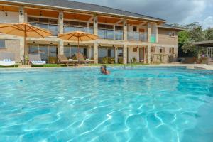 a man is swimming in a swimming pool at Olesamara Collection in Nanyuki