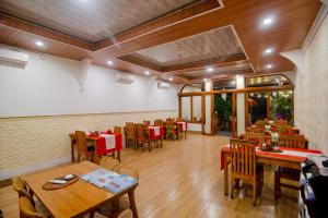 a dining room with wooden tables and chairs at Eric Dolphin Villa in Lovina
