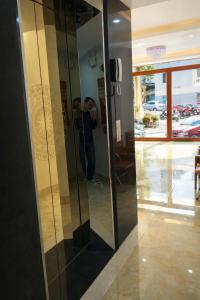 a man taking a picture of a glass elevator at Sail Hotel Hạ Long in Ha Long
