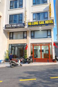 a hotel with motorcycles parked in front of it at Sail Hotel Hạ Long in Ha Long
