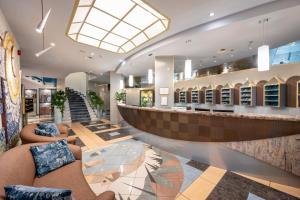 a hotel lobby with couches and a bar at Hotel Luna in Bibione