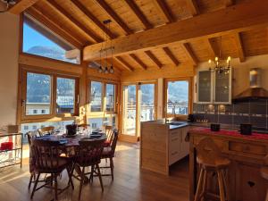 a kitchen and dining room with a table and chairs at Sublime appartement avec terrasse - Centre BSM in Bourg-Saint-Maurice