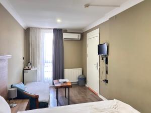 a hotel room with a bed and a tv on the wall at Centrum Hotel in Ankara