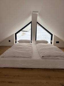 a large white bed in a room with a window at Apartament Świerkowa Osada in Istebna