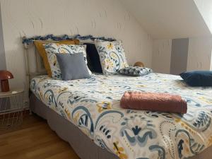 a bedroom with a bed with a blue and white comforter at Macasa chambres et table d'hôte in Coolus