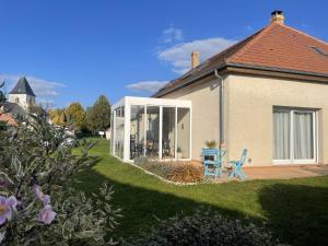 a house with a large window and a blue chair at Macasa chambres et table d'hôte in Coolus