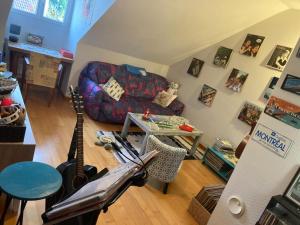 a living room with a guitar and a couch at Macasa chambres et table d'hôte in Coolus
