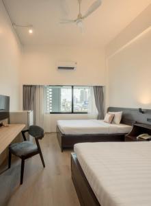 a hotel room with two beds and a chair at The Krungkasem Srikrung Hotel in Bangkok +88 photos