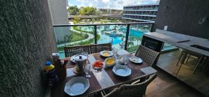 a table with food on top of a balcony at Beach Class Verano Muro Alto in Porto De Galinhas