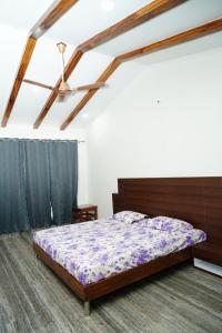 a bedroom with a bed with a purple comforter at Badrika Farm's in Rewa +56 photos