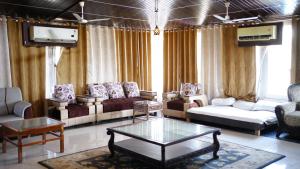 a living room with couches and a coffee table at Badrika Farm's in Rewa
