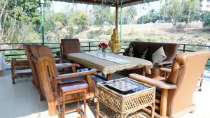 a patio with a table and chairs on a deck at Badrika Farm's in Rewa