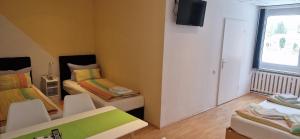 a room with two beds and a flat screen tv at Pension Stechlinsee in Neuglobsow