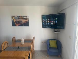 a dining room with a table and a tv on the wall at Andreja in Kustići