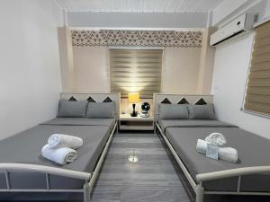 two beds in a room with a lamp and towels at Bila Boutique Hotel in Lagao II