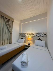 a bedroom with two beds and a window at Bila Boutique Hotel in Lagao II
