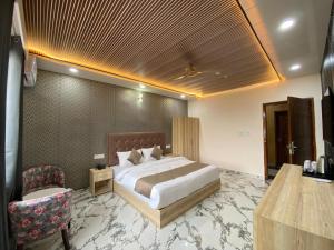 a hotel room with a bed and a chair at Hotel Ganga Pearl in Rishīkesh