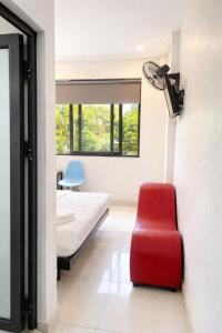 a bedroom with a bed and a red chair at YÊN HÒA MOTEL in Hanoi