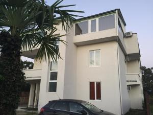 a white building with a car parked in front of it at BSG Rustaveli 184 in Kobuleti
