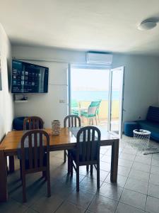 a dining room table and chairs with a view of the ocean at Andreja in Kustići