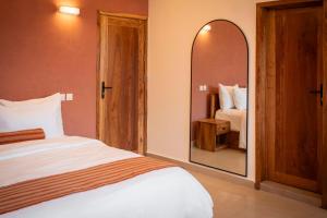a bedroom with a bed and a large mirror at Résidence L'Eau Vive in Cotonou