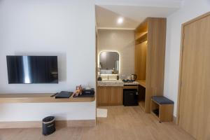 a room with a kitchen with a desk and a television at C&M Hotel in Phan Rang–Tháp Chàm