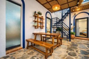 a table and benches in a room with a staircase at Doc Bien Homestay Mui Ne - Entire Home in Ấp Khánh Phước (1) +38 photos