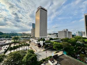 a tall building in a city with a street at Swiss Hotel Kuala Lumpur in Kuala Lumpur