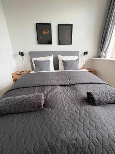 a bedroom with a large gray bed with two pillows at PENDING Queen Bedroom with Balcony in Shared Apartment in Copenhagen