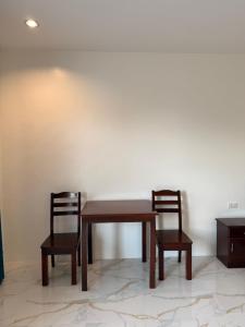 a table and two chairs sitting next to a wall at Sea La Vie Guesthouse in Pooc