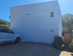 a white garage with a car parked next to it at Deep South Suites in Cape Town