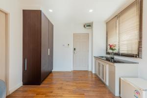 a kitchen with white walls and a wooden floor at ZAYN Bangna Hotel in Bangna