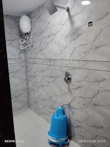 a blue fire hydrant in a bathroom with a marble wall at Hotel Pine Lake in Ahmedabad +7 photos